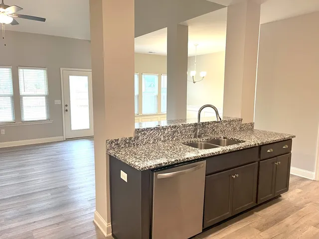 a bathroom with a granite countertop sink and a large mirror