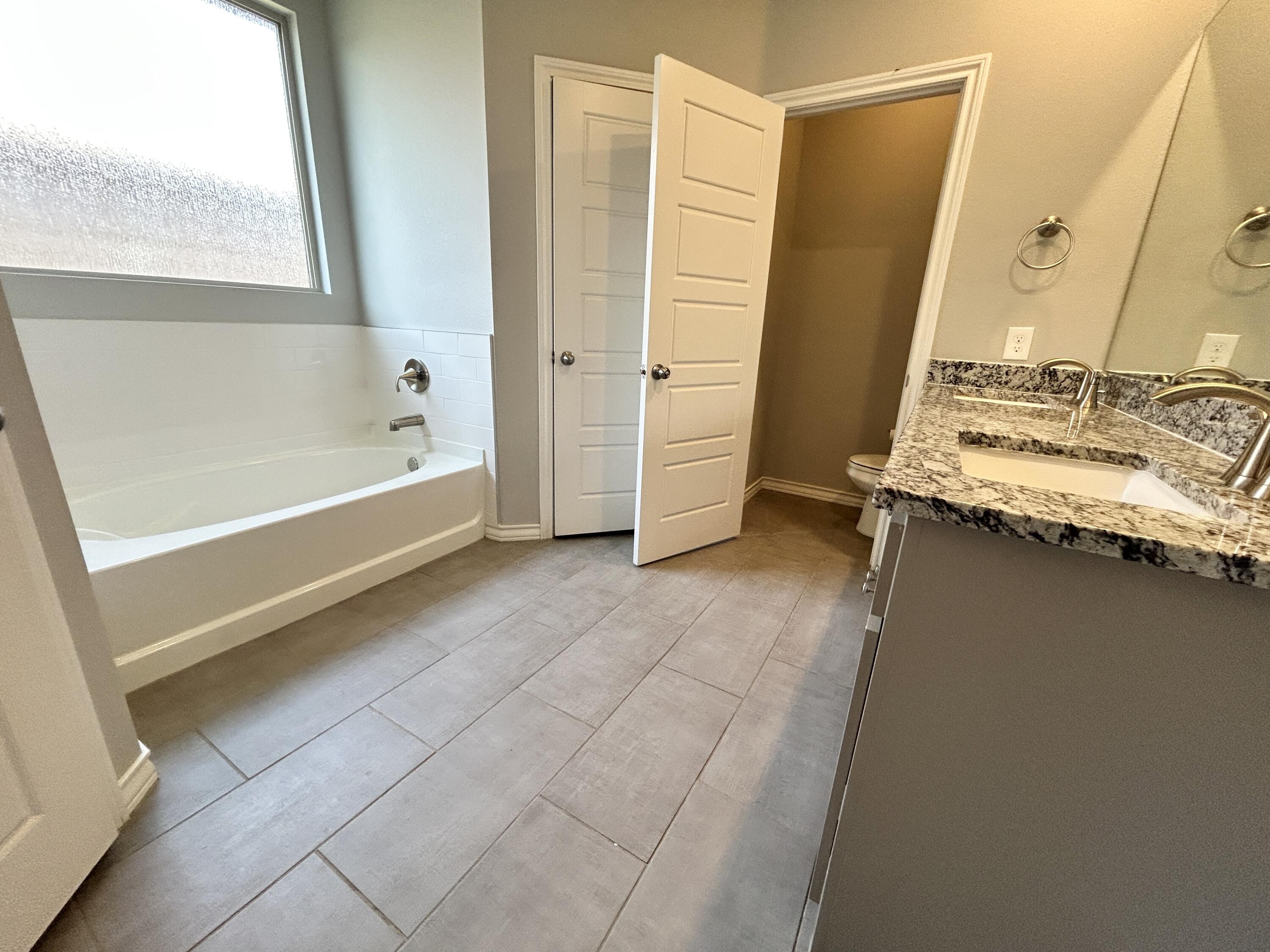 7612 61st Street Lubbock, TX 79407 - Photo 10 of 15 a bathroom with a tub and a sink