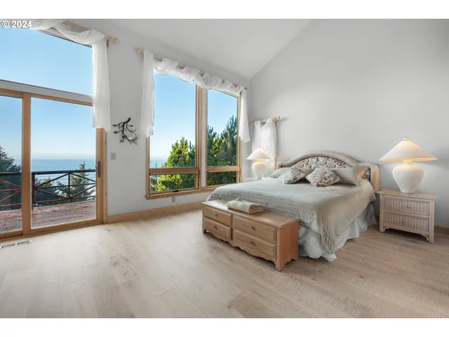 a bedroom with a bed a couch and large window