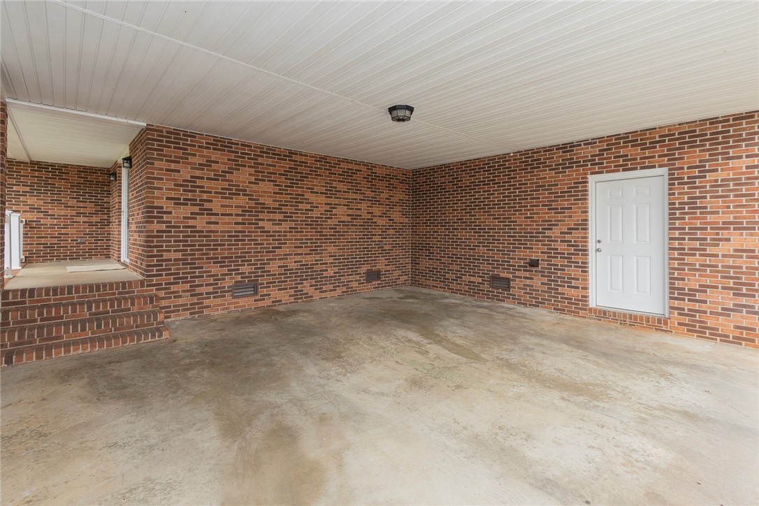 417 Greenmeadow Circle Anderson, SC 29626 - Photo 4 of 41 This functional carport features durable brick construction and a secure entry door, providing practical shelter.