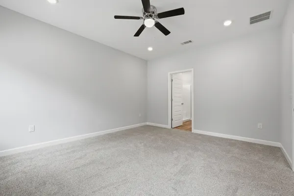 an empty room with closet and a ceiling fan