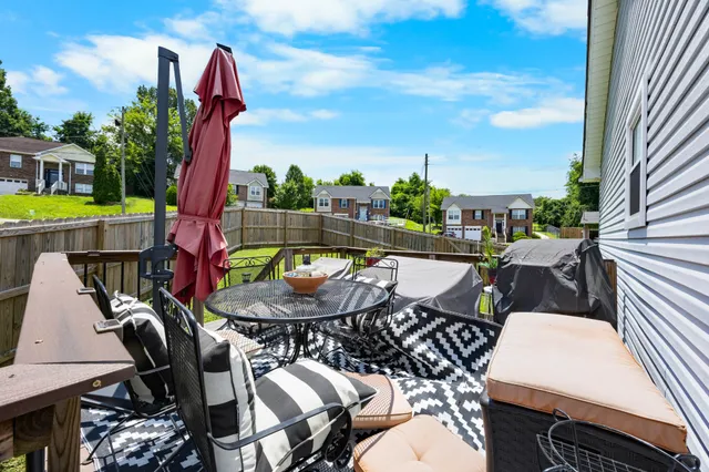 a view of a patio with table and chairs with wooden floor and fence
