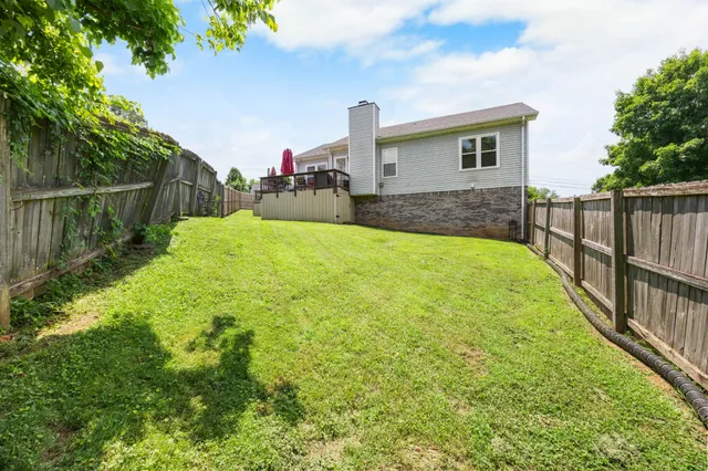 a view of a house with backyard and a tree