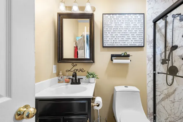 a bathroom with a sink a toilet and a mirror