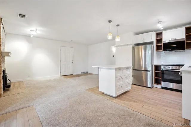 a view of a kitchen with a sink and refrigerator in it