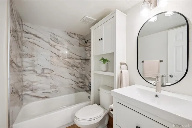 a bathroom with a sink a toilet and a mirror