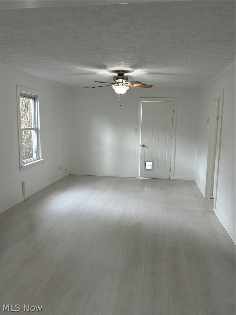 357 Roxboro Road Vermilion, OH 44089 - Photo 3 of 11 Empty room with a textured ceiling, light wood finished floors, and a ceiling fan