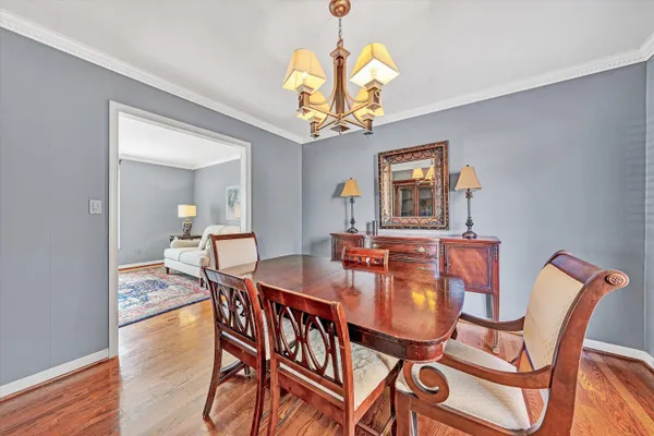 a dining room with furniture a chandelier and wooden floor