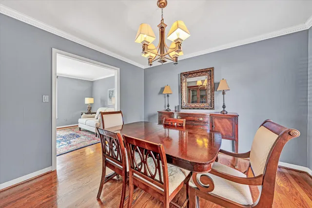a dining room with furniture a chandelier and wooden floor