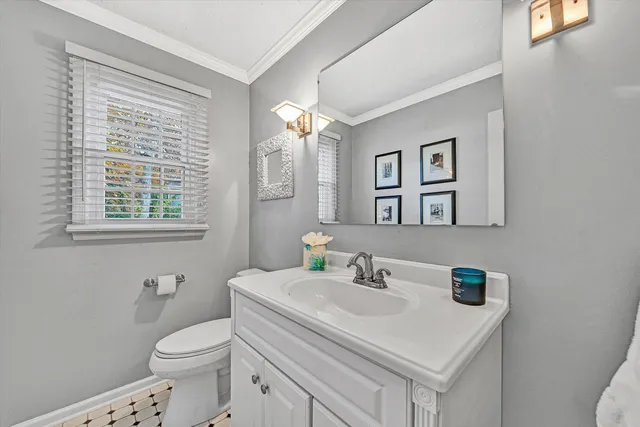 a bathroom with a sink vanity mirror and toilet