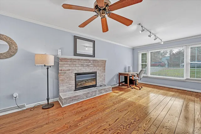 a view of a livingroom with a fireplace and cabinet with wooden floor