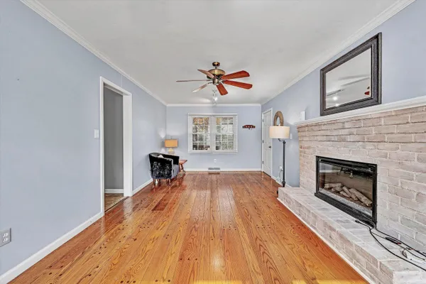 a view of empty room with fireplace and wooden floor