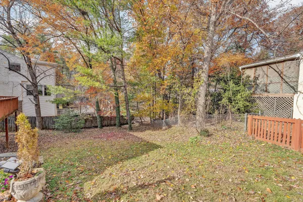 a front view of a house with a garden and trees