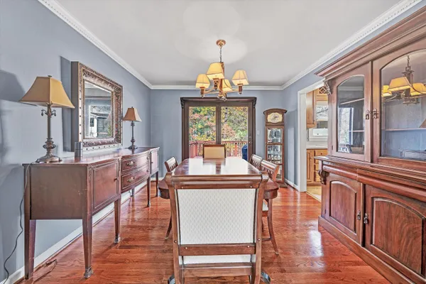 a dining room with wooden floor and a chandelier