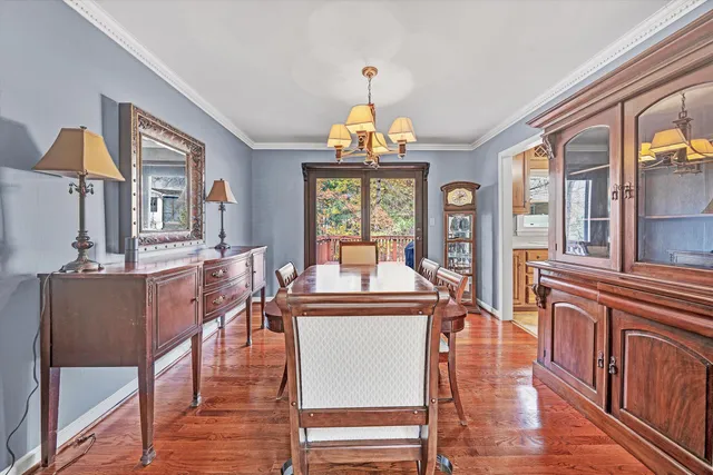 a dining room with wooden floor and a chandelier