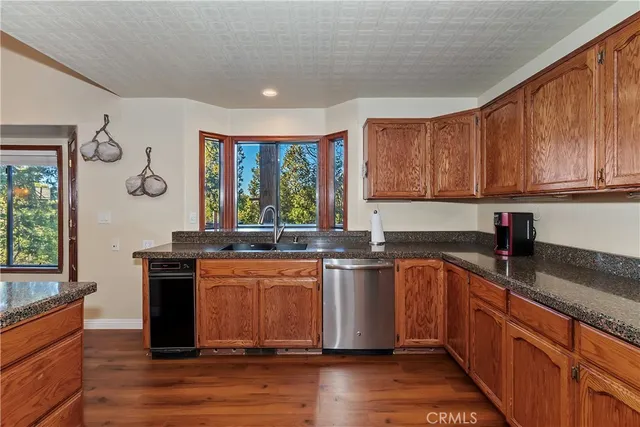 a kitchen with stainless steel appliances granite countertop a sink stove and wooden cabinets