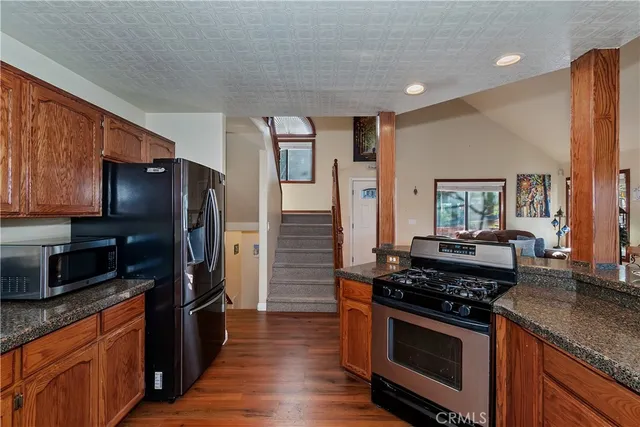 a kitchen with stainless steel appliances granite countertop a stove refrigerator and microwave