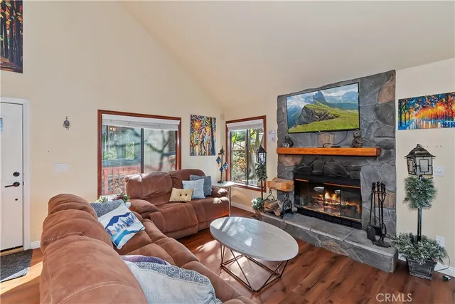 a living room with furniture a fireplace and a large window