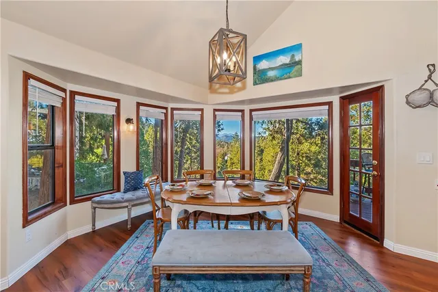 a dining room with furniture a chandelier and wooden floor