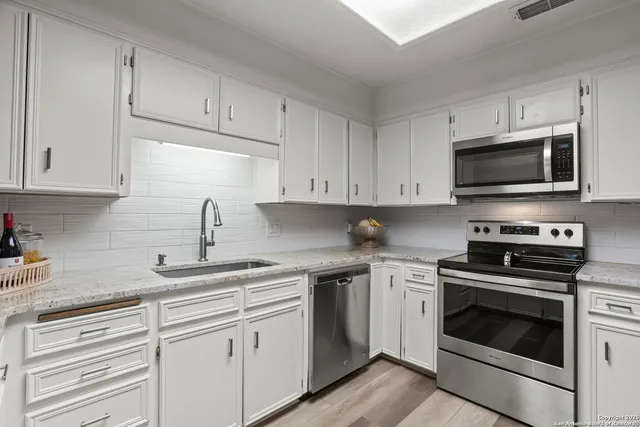 a bedroom with a bed chandelier and a window