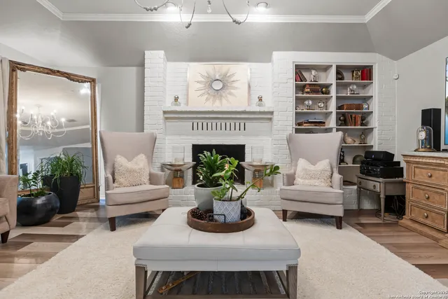 a living room with furniture a chandelier and a flat screen tv