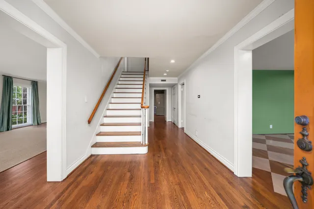 a view of a hallway with wooden floor and stairs