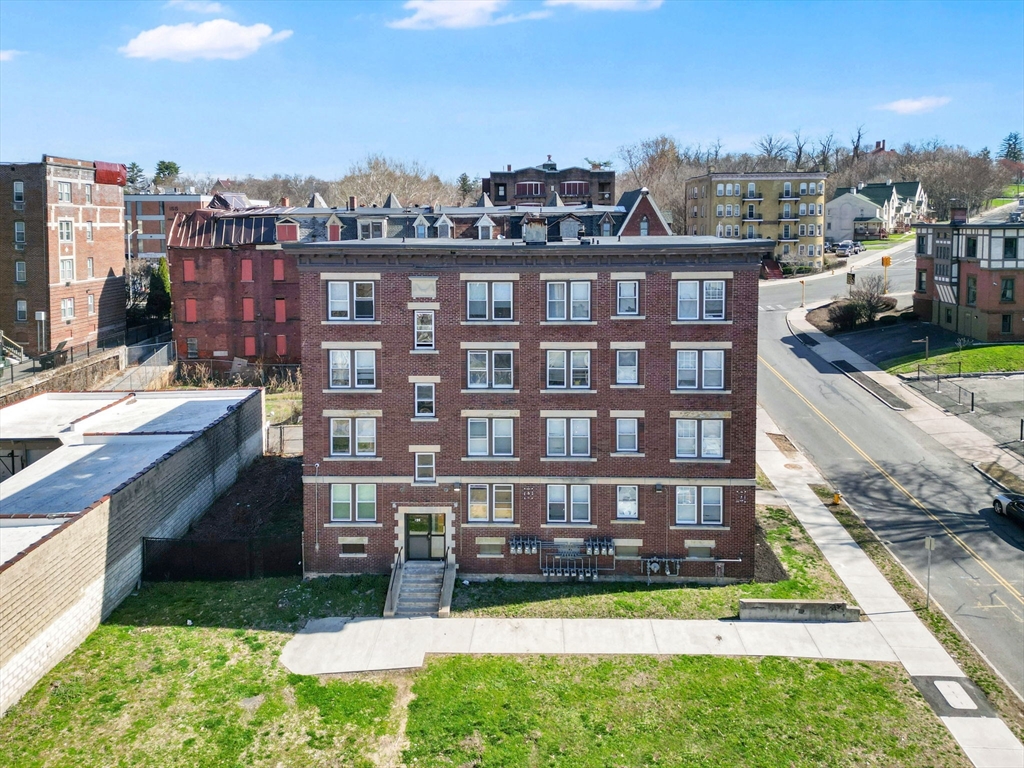a view of a brick building next to a yard