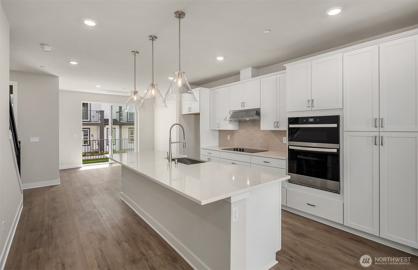 20347 90th Drive Northeast, Unit B Bothell, WA 98011 - Photo 2 of 8 a large kitchen with kitchen island a stove a refrigerator a sink dishwasher and white cabinets with wooden floor
