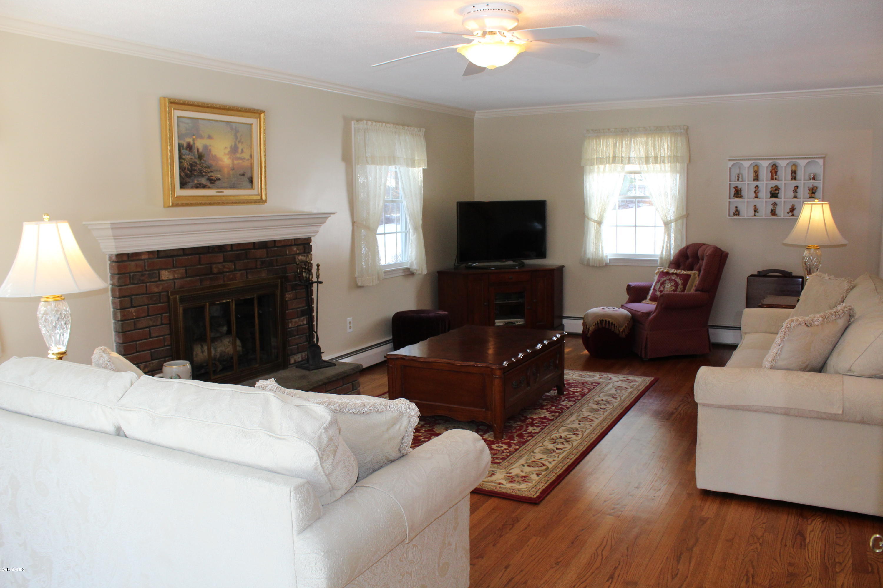 125 Dublin Road Richmond, MA 01201 - Photo 4 of 38 a living room with furniture a fireplace and a flat screen tv
