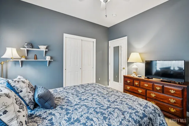 a bedroom with a bed and a flat tv screen on dresser