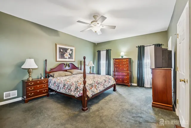 a bedroom with a bed and a refrigerator