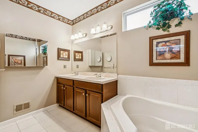 a bathroom with a tub a sink and a mirror