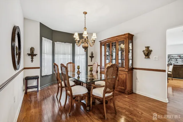 a dining room with furniture a chandelier and wooden floor
