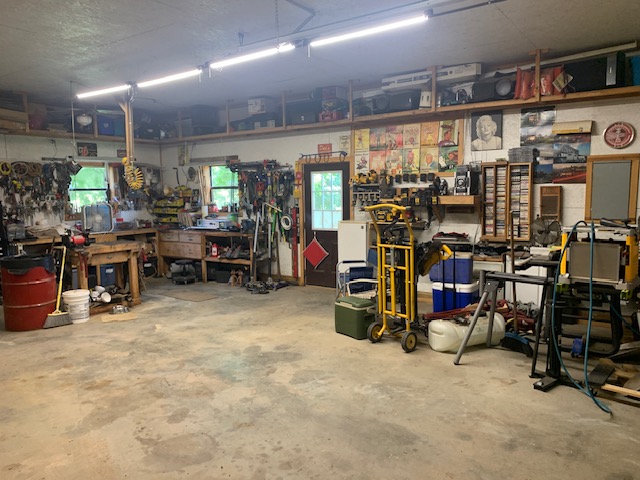 2026 Dry Creek Road St. Joe, AR 72675 - Photo 34 of 60 Concrete flooring, overhead strip lighting, built-in shelving, two windows, and a wood-panel door