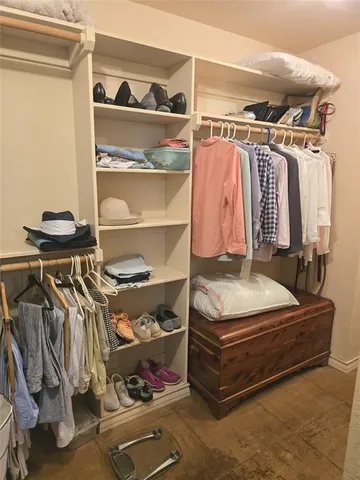 a view of walk in closet with clothes and shoes