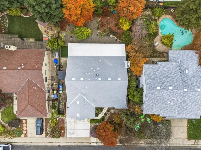 an aerial view of a house with a yard and a large tree