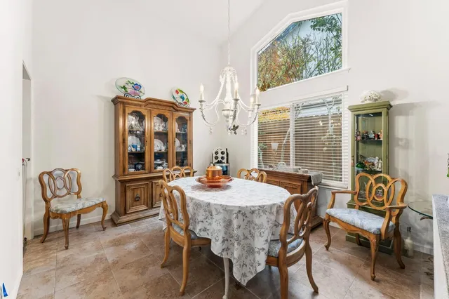 a dining room with furniture a rug and a floor to ceiling window