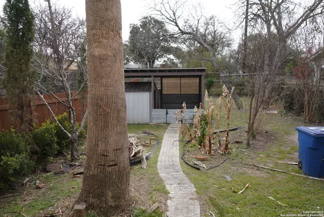 a view of a patio with table and chairs with wooden fence and plants