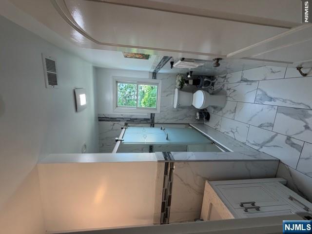 177 Maple Street Fairview, NJ 07022 - Photo 12 of 24 a bathroom with a sink a toilet and a mirror