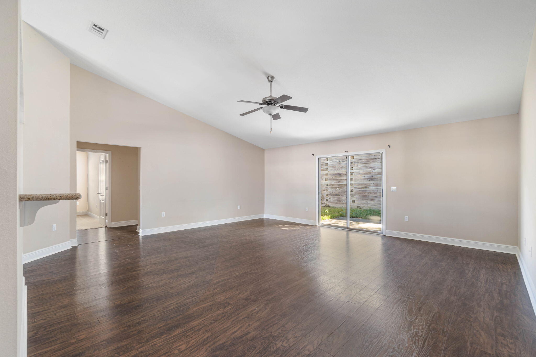 4561 Hermosa Road Crestview, FL 32539 - Photo 6 of 27 an empty room with wooden floor and windows