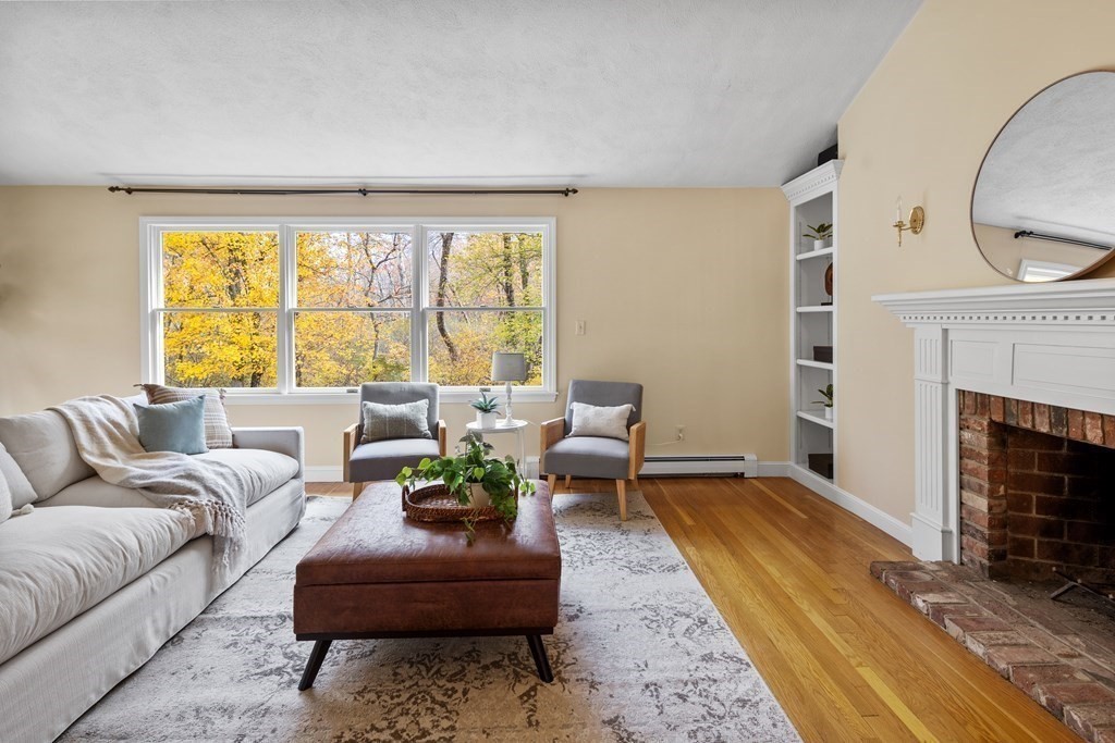 56 Sherburne Road South Lexington, MA 02421 - Photo 18 of 42 a living room with furniture a large window and a fireplace