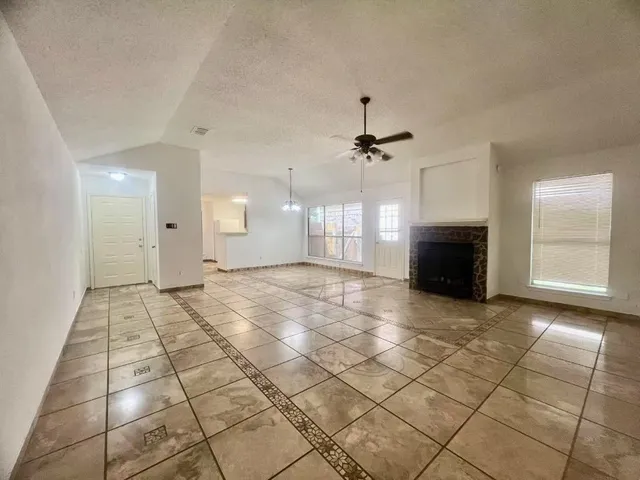 a view of empty room with wooden floor and fireplace