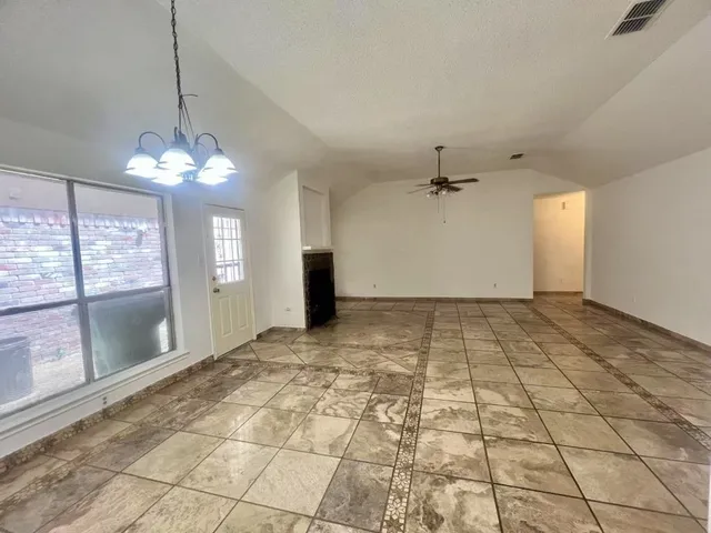 a view of a livingroom with a chandelier fan and windows