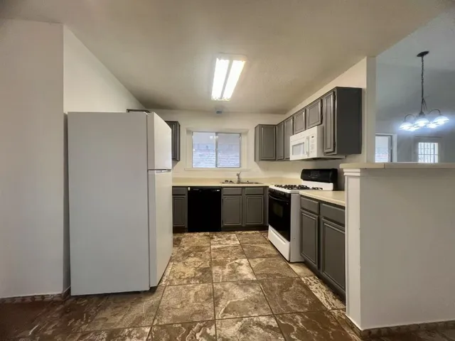 a kitchen with a refrigerator sink and cabinets
