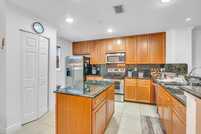 a kitchen with stainless steel appliances granite countertop a sink stove and refrigerator