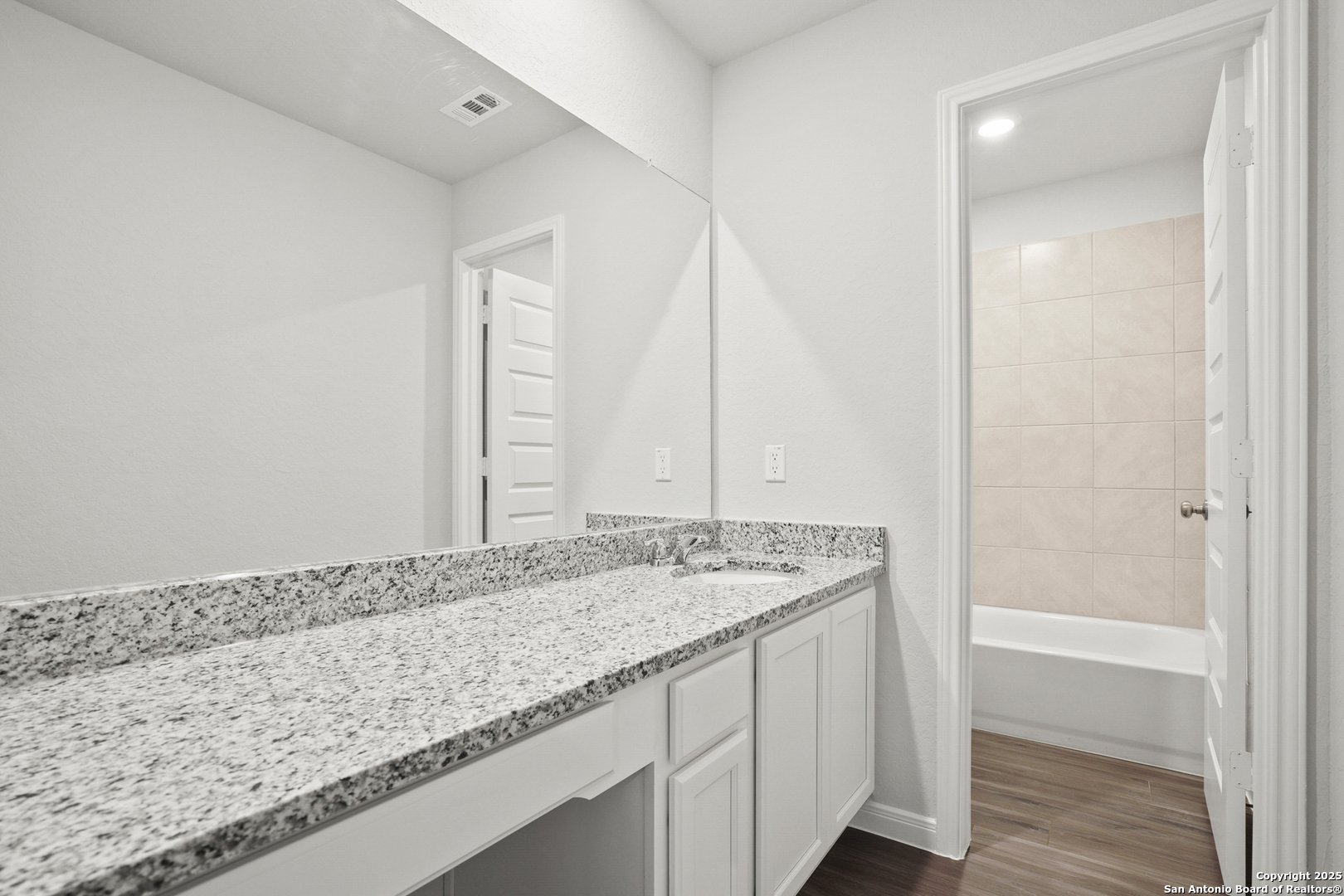 13636 Helton Pass St. Hedwig, TX 78152 - Photo 18 of 34 a bathroom with a granite countertop sink and a mirror