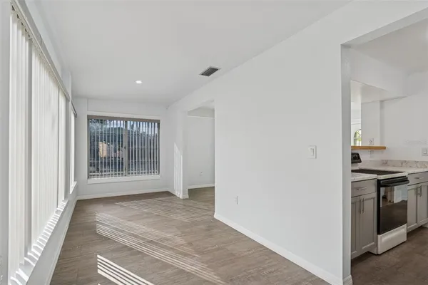 a view of empty room with wooden floor and fan