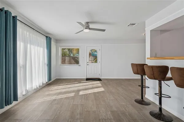 a view of an empty room with window and wooden floor