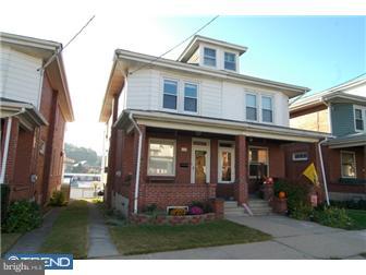 1024 Fern Avenue Reading, PA 19607 - Photo 1 of 12 a view of a brick house with large windows and a yard