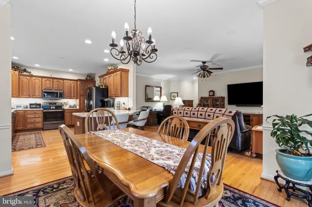 a view of a dining room with furniture a kitchen and chandelier